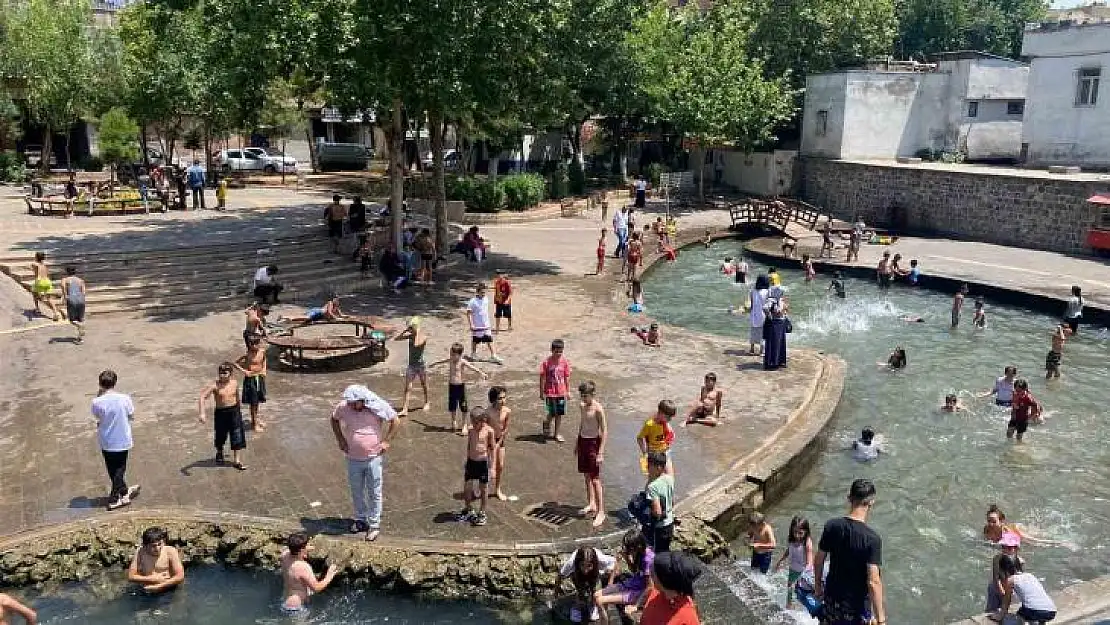 Diyarbakır'da çocuklar ailelerinin nezaretinde süs havuzunda serinliyor